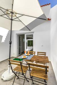 a dining room with a table and chairs and an umbrella at Costa Mar III in Peniche