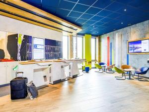 un ufficio con sedie, tavoli e un soffitto blu di ibis budget Bremen City Center a Brema