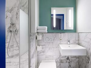 ein Bad mit einem Waschbecken und einem Spiegel in der Unterkunft ibis budget Bremen City Center in Bremen