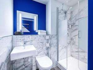 een badkamer met een wastafel, een toilet en een douche bij ibis budget Bremen City Center in Bremen