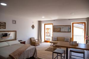 1 dormitorio con 1 cama y sala de estar con mesa en A casa do Xastre, en Allariz