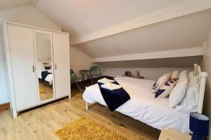 - une chambre avec un grand lit et un grand miroir dans l'établissement 2 bedroom Victorian canal side terrace house., à Hebden Bridge