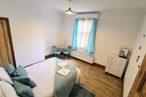 a bedroom with a bed and a table and a window at 2 bedroom Victorian canal side terrace house. in Hebden Bridge