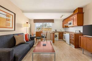 a living room with a couch and a kitchen at Ramada Hotel & Suites by Wyndham Costa del Sol in Fuengirola