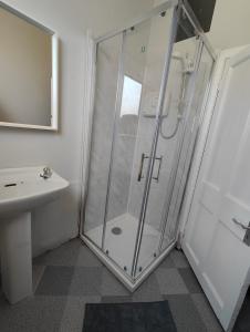 uma casa de banho com um chuveiro e um lavatório. em Recently Renovated Dublin City House em Dublin