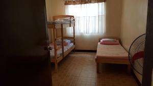 Postel nebo postele na pokoji v ubytování Sanctuary Transient House Bacolod