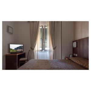 a hotel room with a bed and a television at Hotel Margherita in Monterosso al Mare