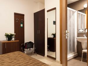 a bathroom with a bed and a sink and a mirror at Hotel Margherita in Monterosso al Mare