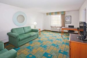 sala de estar con sofá verde y mesa en Norwood Inn & Suites Merrillville en Merrillville