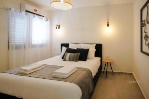 a bedroom with a large bed with towels on it at YalaRent Orchid Boutique Apartments in Eilat