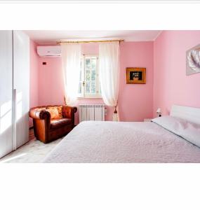 奧古斯塔的住宿－Villa Angela，卧室设有粉红色的墙壁、一张床和椅子