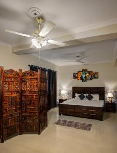 - une chambre avec un lit et un ventilateur de plafond dans l'établissement Meera Homes, à Dehradun
