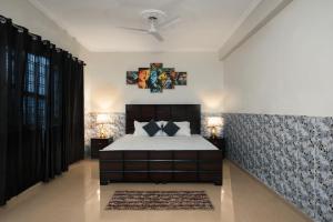 - une chambre avec un grand lit et deux lampes dans l'établissement Meera Homes, à Dehradun