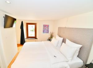 ein Schlafzimmer mit einem großen weißen Bett mit weißen Kissen in der Unterkunft Boato Bistrot & Bed in Tegna