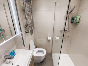 een witte badkamer met een douche en een toilet bij Modern 3 Bedroom Apartment in Kensington in Londen