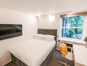 sypialnia z łóżkiem, biurkiem i oknem w obiekcie Modern 3 Bedroom Apartment in Kensington w Londynie