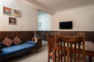 a bedroom with a bed and a tv and a couch at Meera Homes in Dehradun