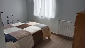 1 dormitorio con cama, ventana y radiador en Apartamento nuevo cerca de la costa y a 15 min de Bilbao!, en Urduliz