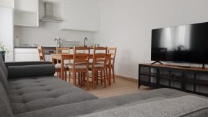a living room with a couch and a table with a television at Apartamento nuevo cerca de la costa y a 15 min de Bilbao! in Urduliz