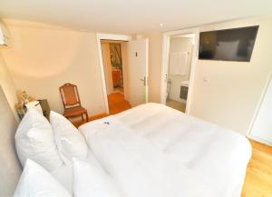- un lit blanc avec des oreillers blancs dans une chambre dans l'établissement Boato Bistrot & Bed, à Tegna