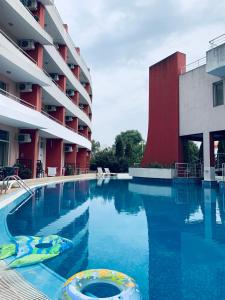 a swimming pool in front of a building at Sunshine Romance Apartment in Kranevo