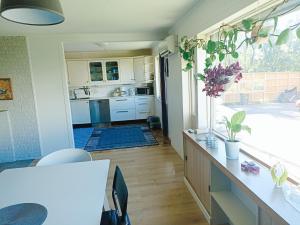 a kitchen with white cabinets and a table in a room at FeelHome 4 bedrooms apartment Polarvegen in Tromsø