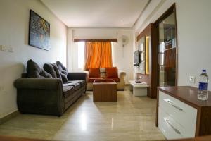 ein Wohnzimmer mit einem Sofa und einem Stuhl in der Unterkunft Emarald Hotel Calicut in Kozhikode