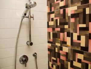 a shower in a bathroom with a mosaic tile wall at InnPisaRentals - Loft in Pisa Historical Center in Pisa