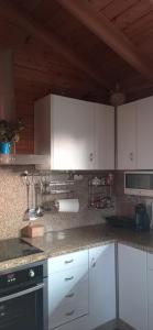 une cuisine avec des placards blancs et un comptoir dans l'établissement Acogedora cabaña con piscina, à Pontevedra