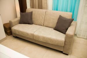 a couch with two pillows on it in a living room at InnPisaRentals - Loft in Pisa Historical Center in Pisa