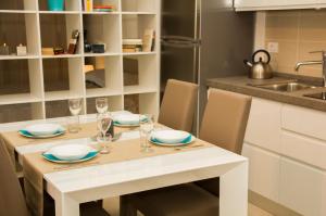 a white table with glasses and plates on it in a kitchen at InnPisaRentals - Loft in Pisa Historical Center in Pisa