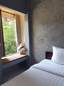 a bedroom with a bed and a window at Cheeva at pai ชีวา แอท ปาย in Pai