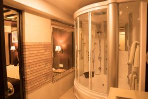 een badkamer met een douche en een spiegel bij Hotel Shaara in Pokhara