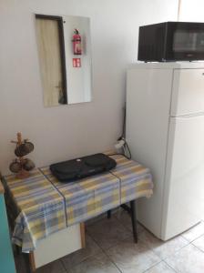 Habitación con mesa y nevera. en Pokoje Goscinne "Anna Maria" en Łeba