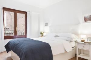 um quarto branco com uma cama grande e uma janela em Apartamento con vistas en centro histórico em Zaragoza