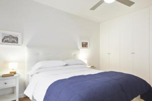 um quarto branco com uma cama e uma ventoinha de tecto em Apartamento con vistas en centro histórico em Zaragoza