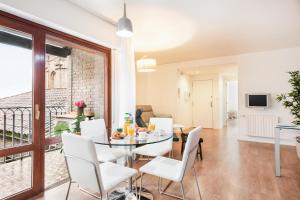 uma sala de jantar e sala de estar com mesa e cadeiras em Apartamento con vistas en centro histórico em Zaragoza