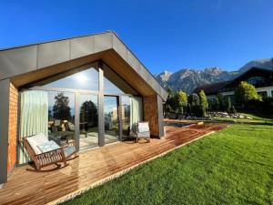a house with a deck with a view of the mountains at Chalet Annelies in Ramsau am Dachstein