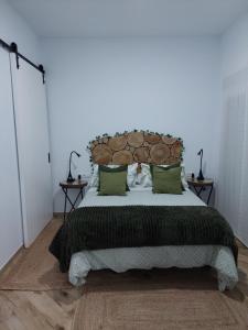 een slaapkamer met een groot bed met groene kussens bij Avocado Suite by Alhaurín Loft City Center in Alhaurín de la Torre