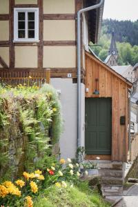 ein Haus mit grüner Tür und ein paar Blumen in der Unterkunft Kulturdenkmal Umgebinde1657 in Bad Schandau