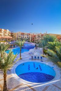 an overhead view of a resort pool with palm trees and buildings at Marina Plaza Hotel Tala Bay in Aqaba