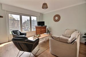 ein Wohnzimmer mit Sofa, Sesseln und Fernseher in der Unterkunft Maison face à Nausicaa in Boulogne-sur-Mer