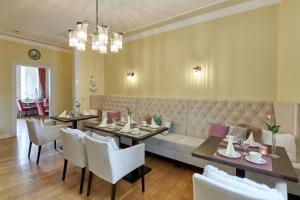 a dining room with tables and chairs and a bench at Hotel Sankt Maximilian in Bernkastel-Kues