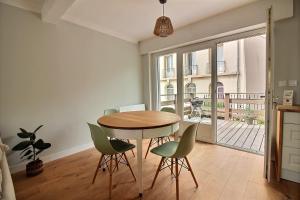 ein Esszimmer mit einem Tisch und grünen Stühlen in der Unterkunft Maison face à Nausicaa in Boulogne-sur-Mer