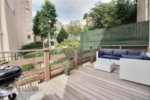 einen Balkon mit einem blauen Sofa auf einer Holzterrasse in der Unterkunft Maison face à Nausicaa in Boulogne-sur-Mer