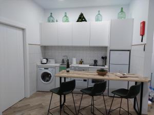 een keuken met een tafel en stoelen en een wasmachine bij Avocado Suite by Alhaurín Loft City Center in Alhaurín de la Torre