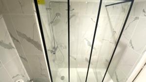 una doccia con porta in vetro in bagno di Studio Bricka - 200m to the beach, parking, clim, terrace a Antibes