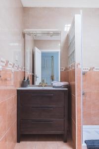 een badkamer met een wastafel en een spiegel bij Home2Book Cozy Sea Views Punta Sardina Lighthouse in Gáldar