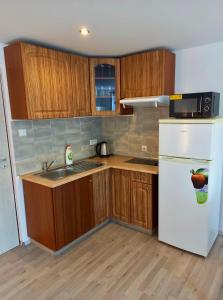 cocina con armarios de madera y nevera blanca en Apartmán Patrik, en Valtice