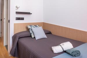 a bed with two pillows on top of it at Residencia Universitaria Málaga Centro in Málaga